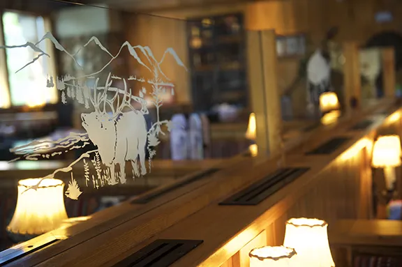 Etched glass divider with elk and mountain scene in the dining room
