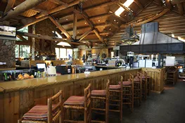 Bar area with log ceiling and rustic stools