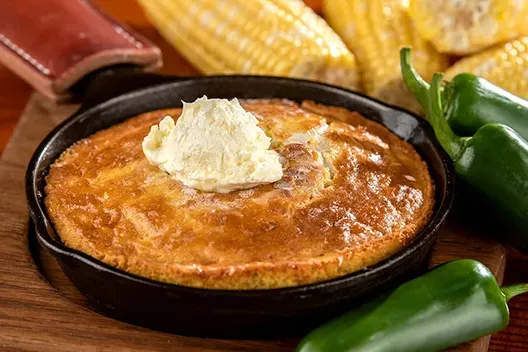 Jalapeno cornbread with butter in a cast iron skillet